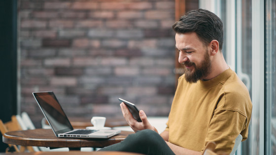 Mann betrachtet Webdesign auf dem Smartphone